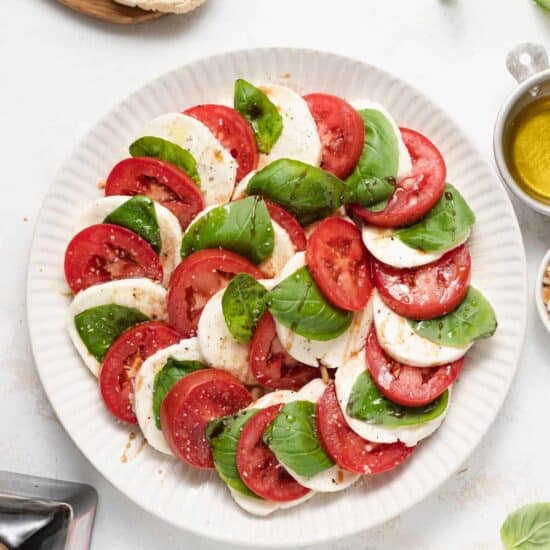 Caprese salad on a plate with fresh basil.