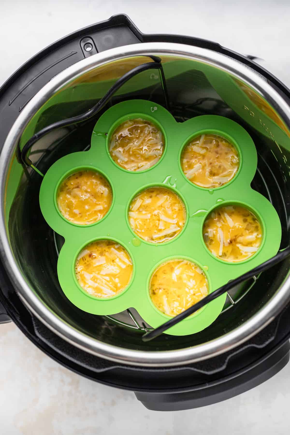 Instant pot cheesy egg bites inside the instant pot ready to be pressure cooked.