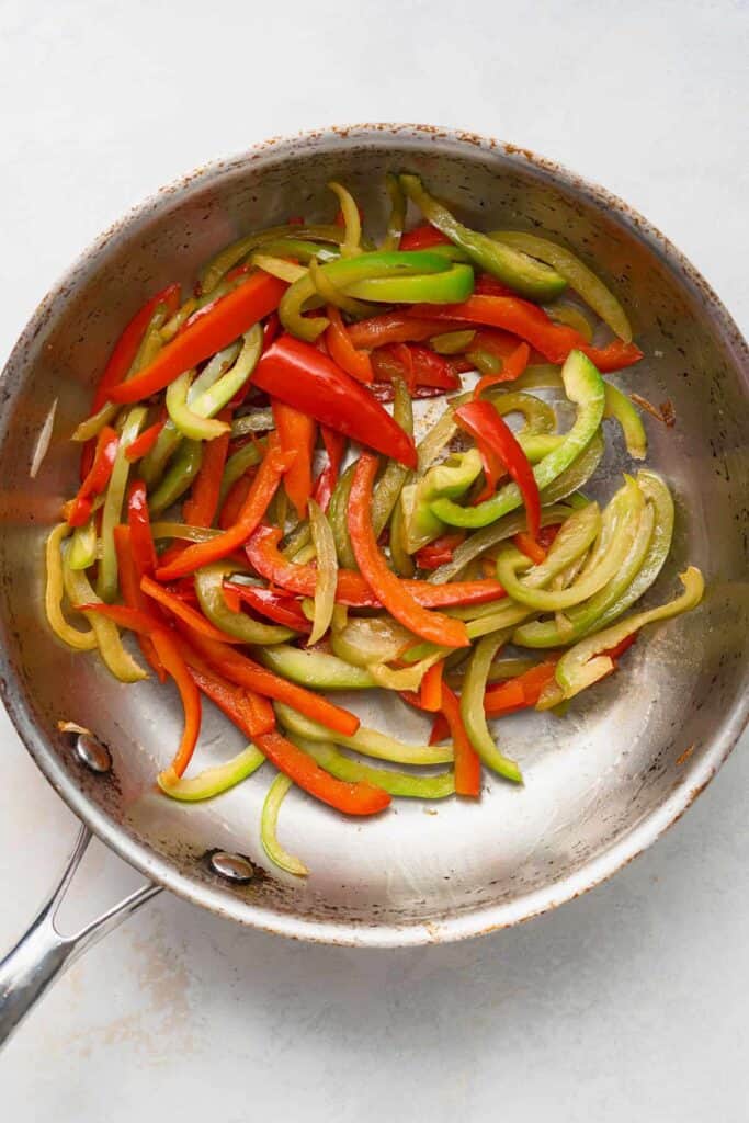 Peppers and onions in a saute pan. 