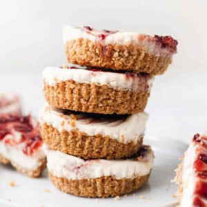 a stack of strawberry cheesecakes on a white plate.