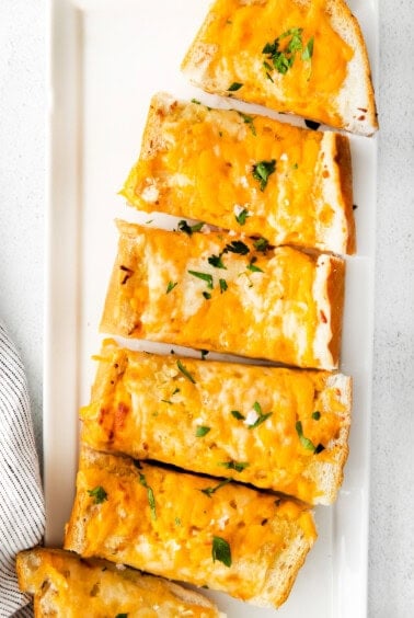 Cheesy garlic bread on plate.