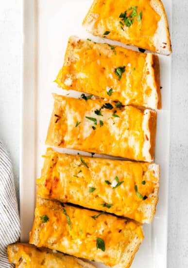 Cheesy garlic bread on plate.