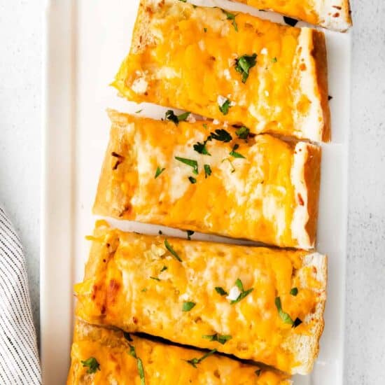 Cheesy garlic bread on plate.