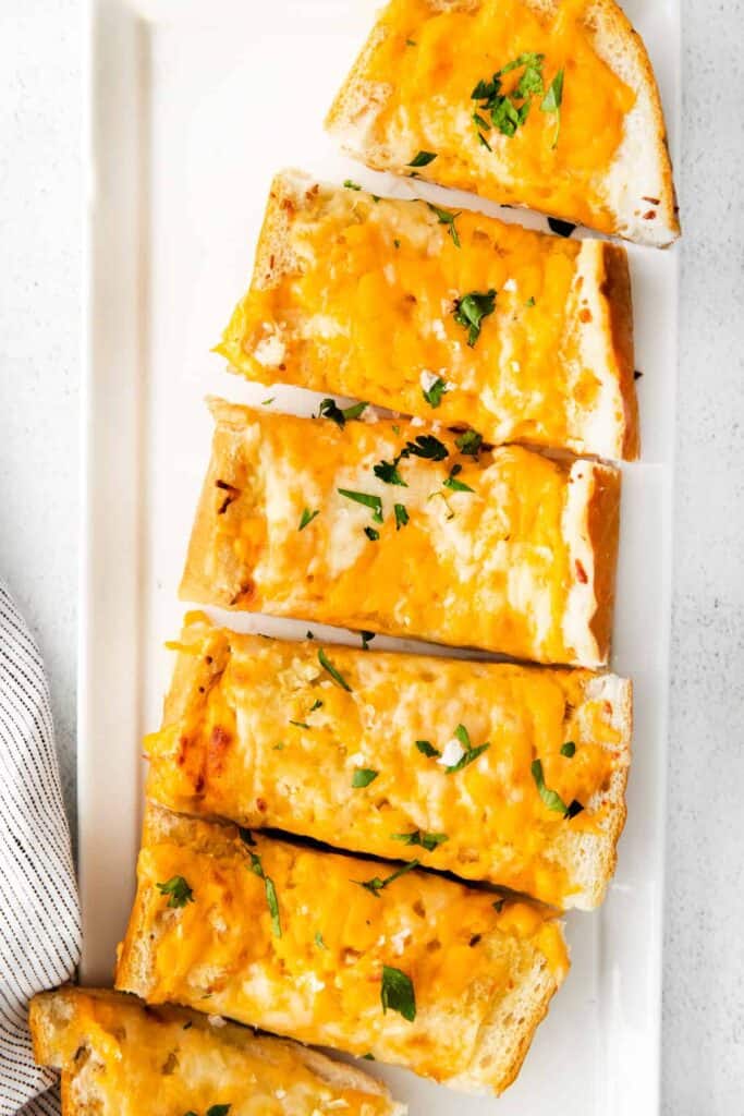 Cheesy garlic bread on a platter. 