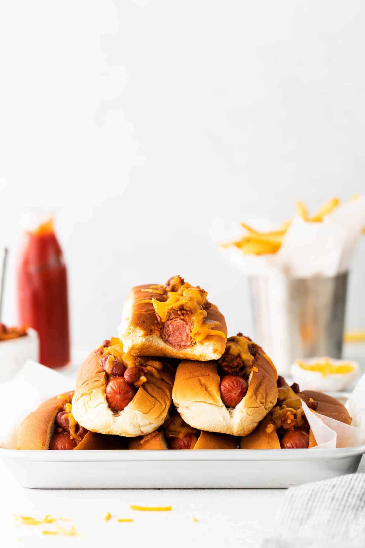 Stack of chili cheese dogs.