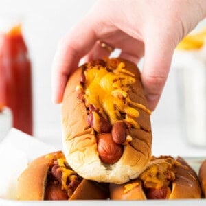 hand holding chili cheese dog