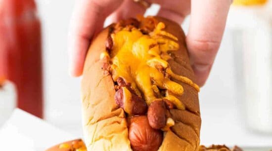 hand holding chili cheese dog