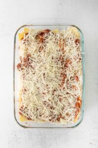a casserole dish filled with spaghetti and meat sauce.