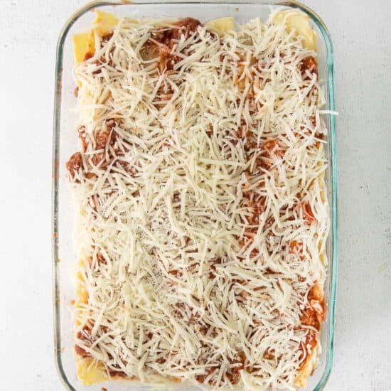 a casserole dish filled with spaghetti and meat sauce.