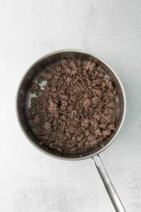 a frying pan filled with ground beef.