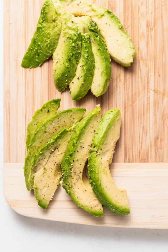 sliced avocado on cutting board.