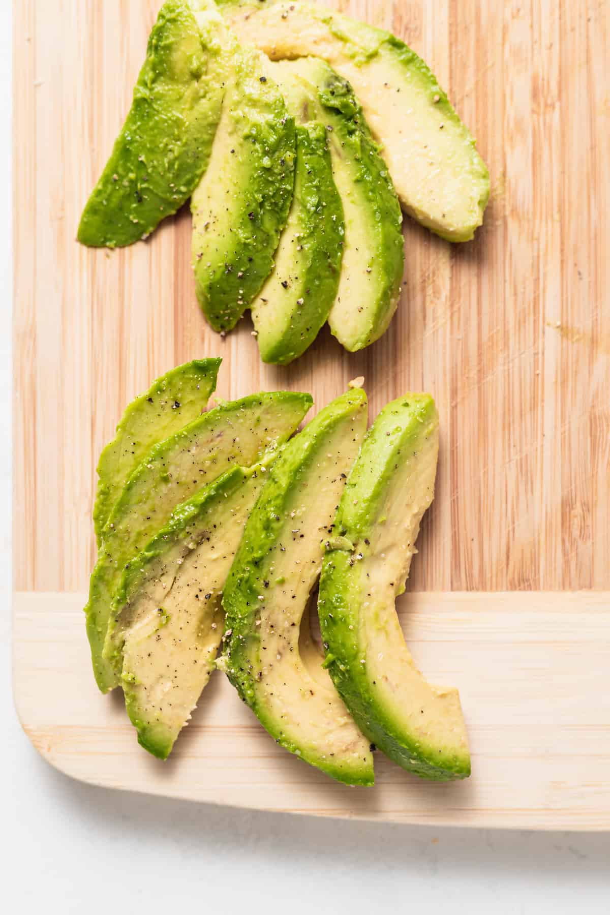 sliced avocado on cutting board.