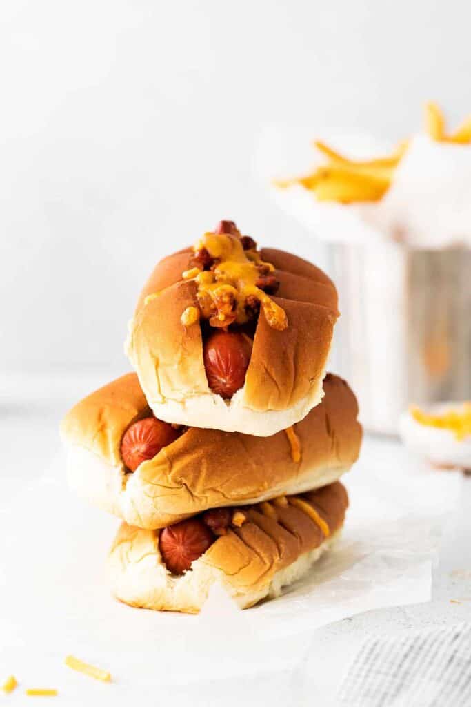Stack of chili cheese dogs.