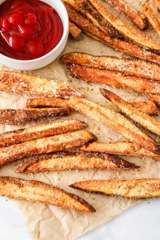 garlic parmesan fries on paper with ketchup