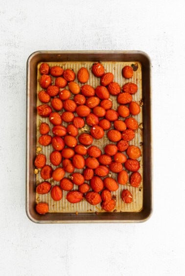 Apricots roasted on a baking sheet served with warm burrata and roasted tomatoes.