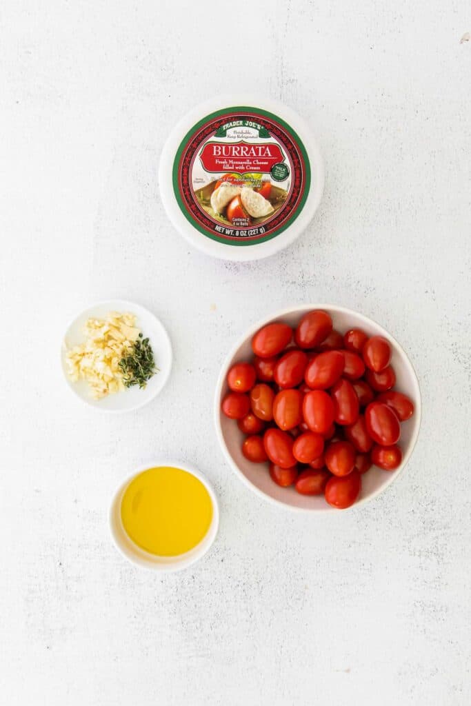 ingredients for warm burrata and roasted tomatoes in small bowls, ready to be mixed together