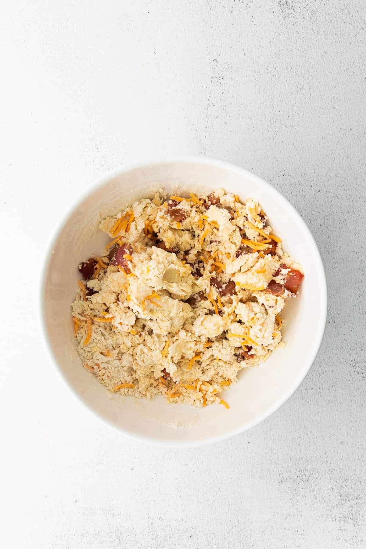 A bowl of bacon and cheddar scone dough. 