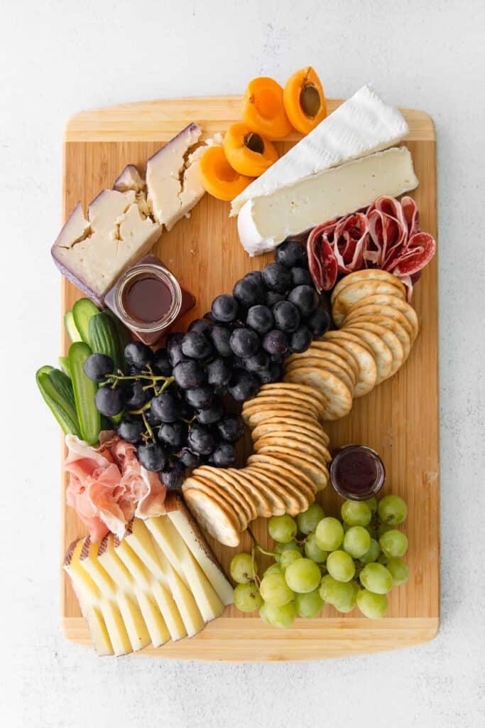 grapes cheese and meat on cutting board