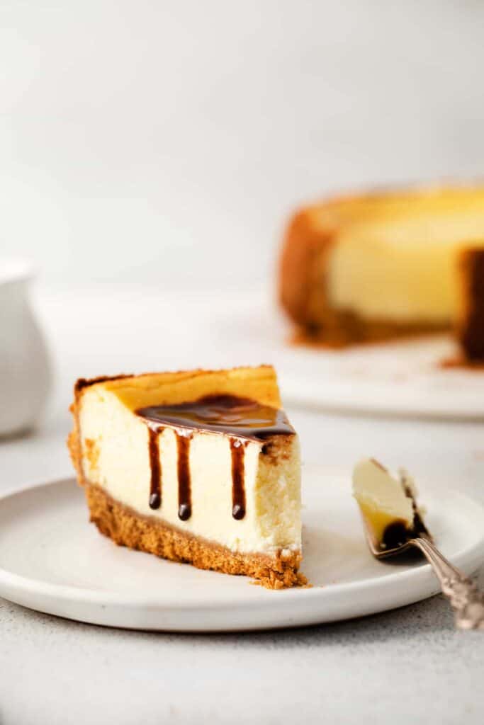 A fork with a bite of cheesecake on it. 