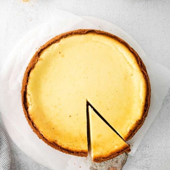 A person slicing a Classic Cheesecake.