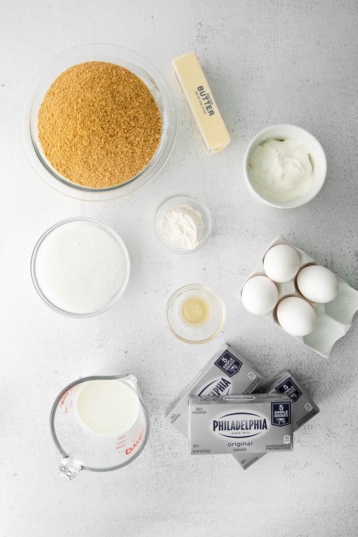 Cheesecake ingredients in small bowls on the counter. 