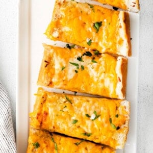 Cheesy garlic bread on a plate.