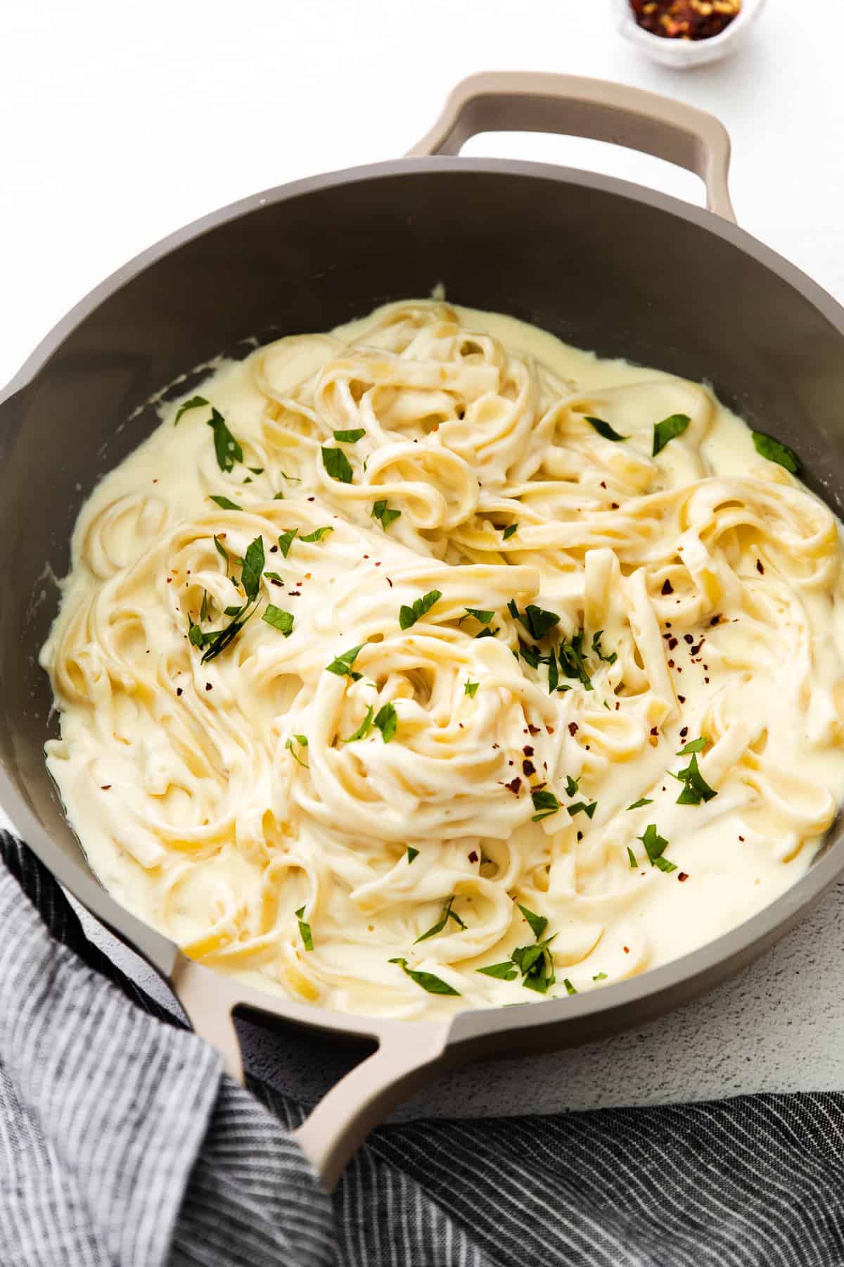 alfredo sauce with cream cheese tossed with fettuccine noodles and topped with parsley.