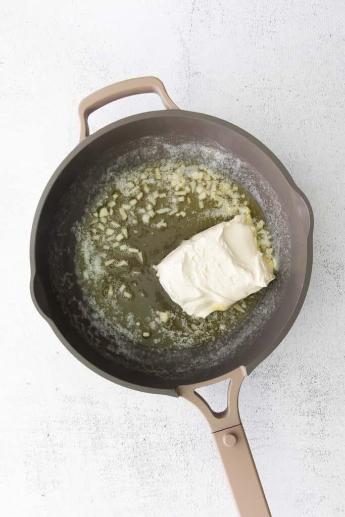 sauteed garlic and butter with cream cheese in a skillet.