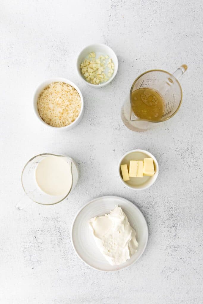 ingredients for alfredo sauce with cream cheese in small bowls