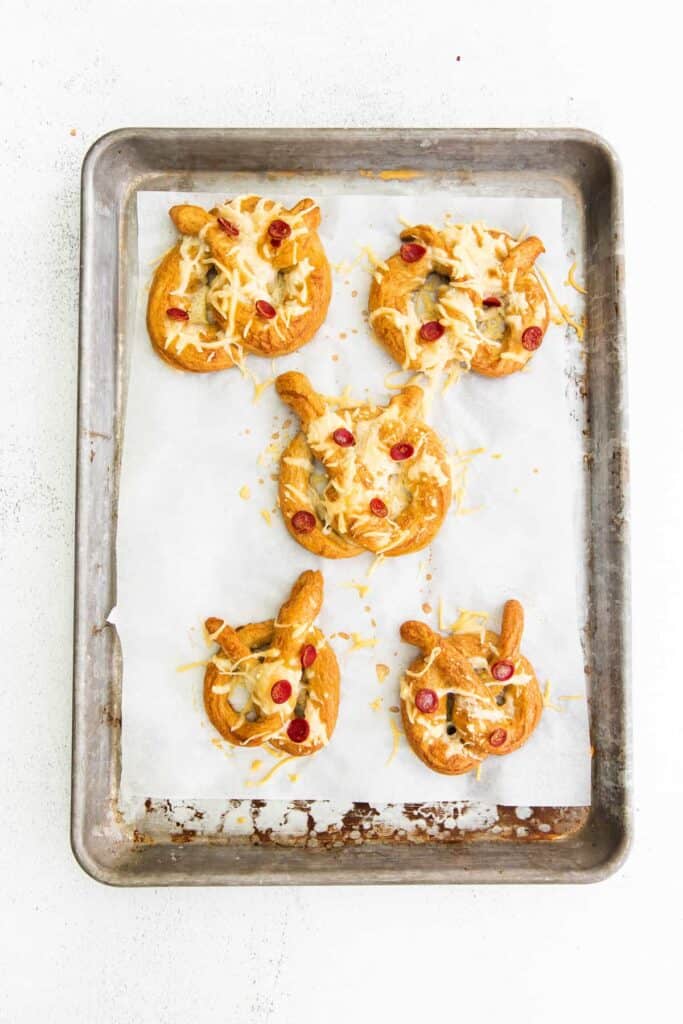 5 soft pretzels on baking sheet