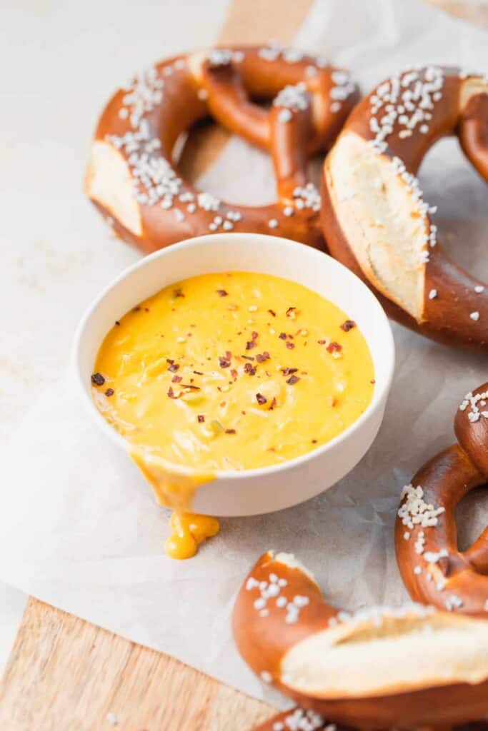 pretzel cheese dip in a bowl next to soft pretzels