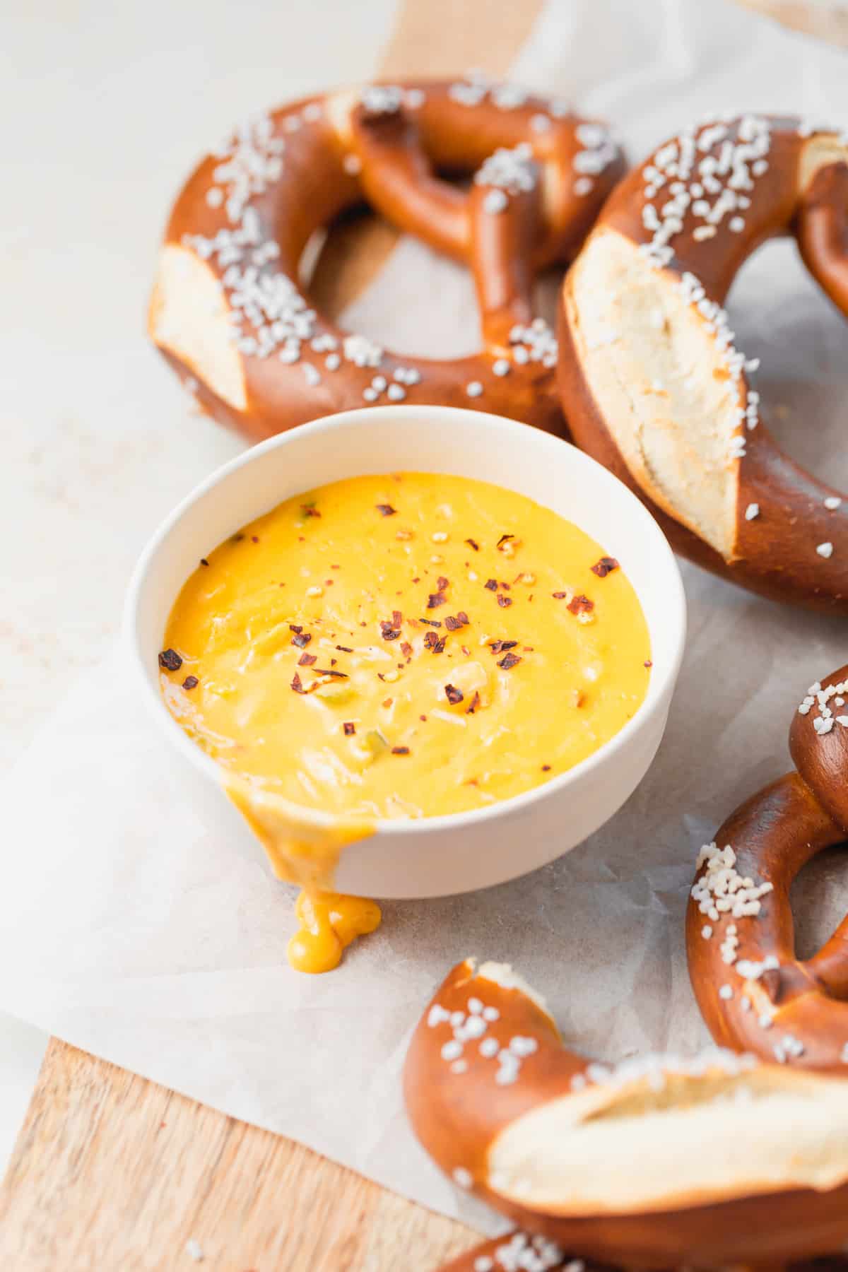 pretzel cheese dip in a bowl next to soft pretzels