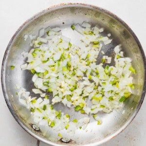 A frying pan with onions sautéing in pretzel cheese dip.