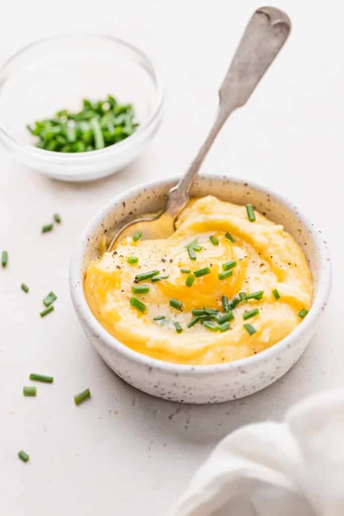 cheese grits in a bowl topped with fresh chives