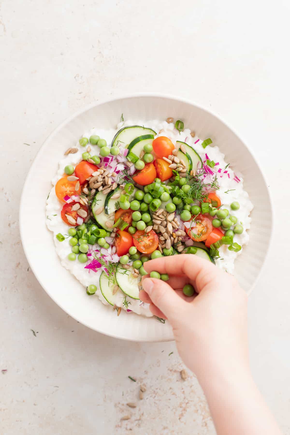 cottage cheese salad being topped with english peas