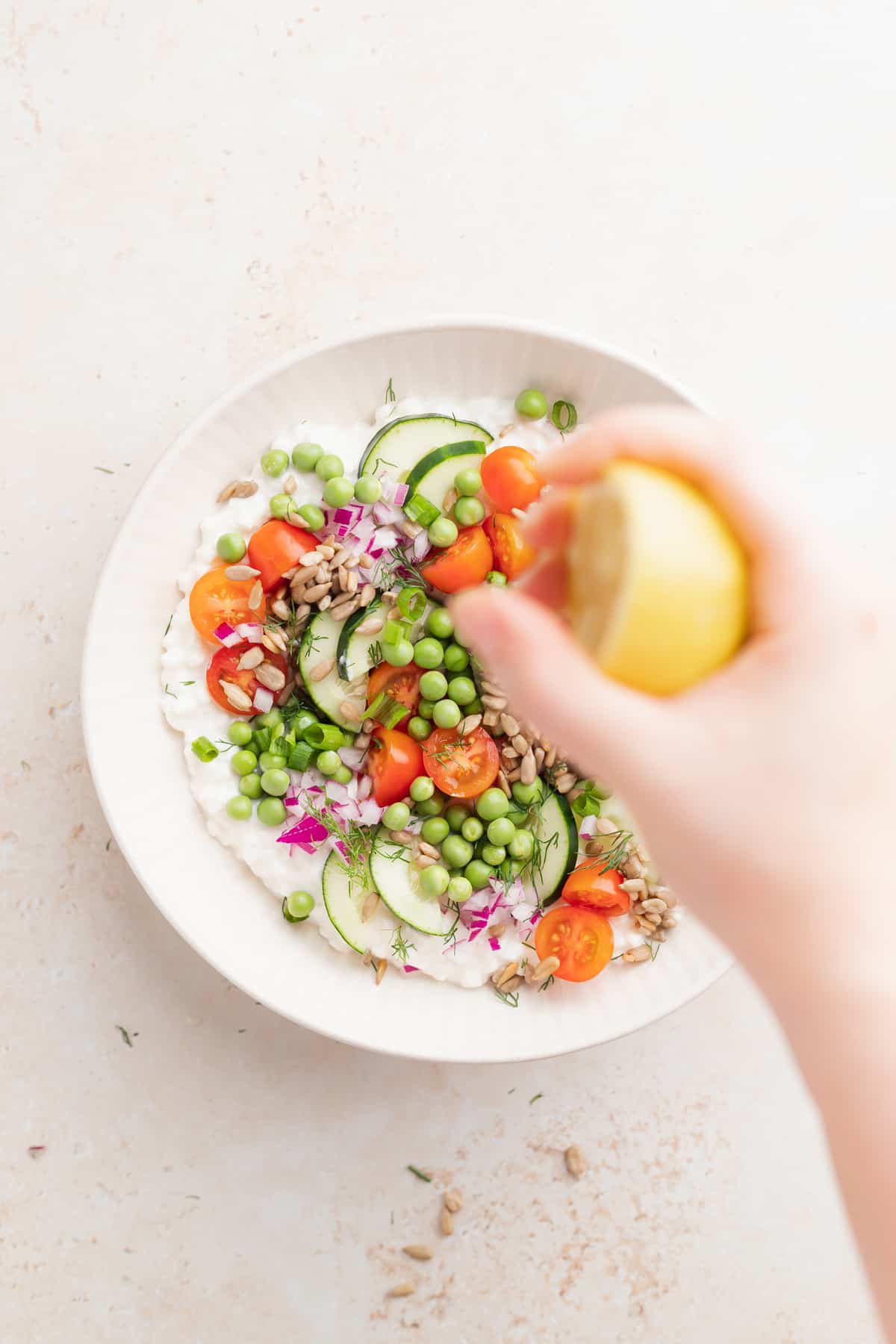 cottage cheese salad with lemon juice being squeezed over it