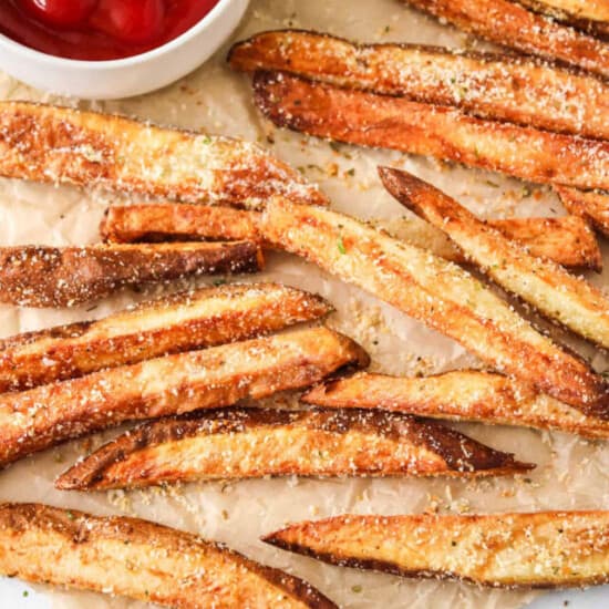 french fries on a baking sheet with ketchup.