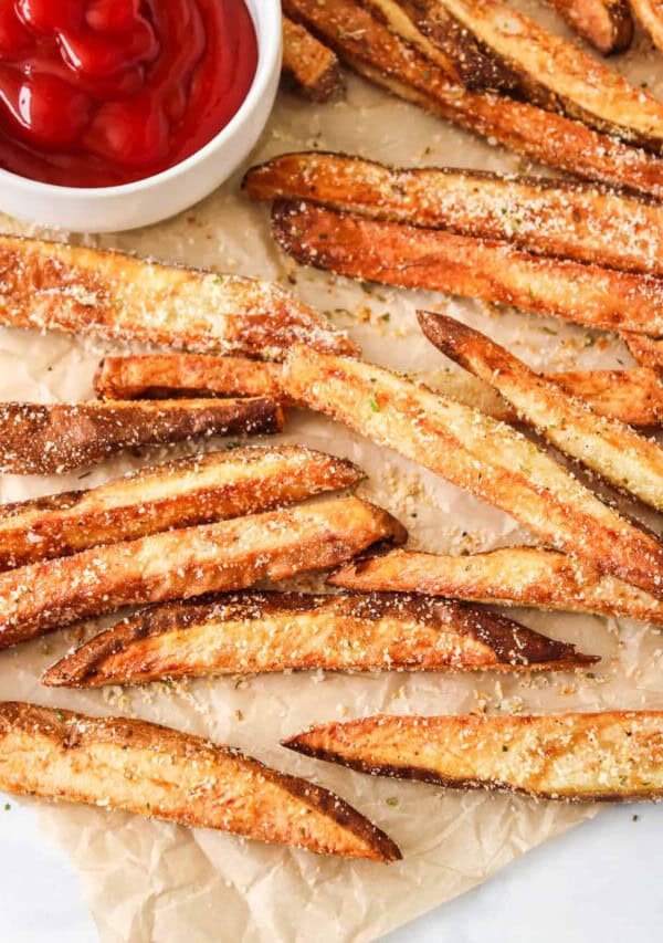 french fries on a baking sheet with ketchup.
