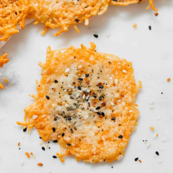 a plate of carrot chips on a white surface.