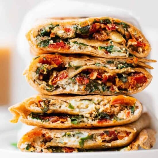 a stack of spinach and artichoke quesadillas on a white plate.