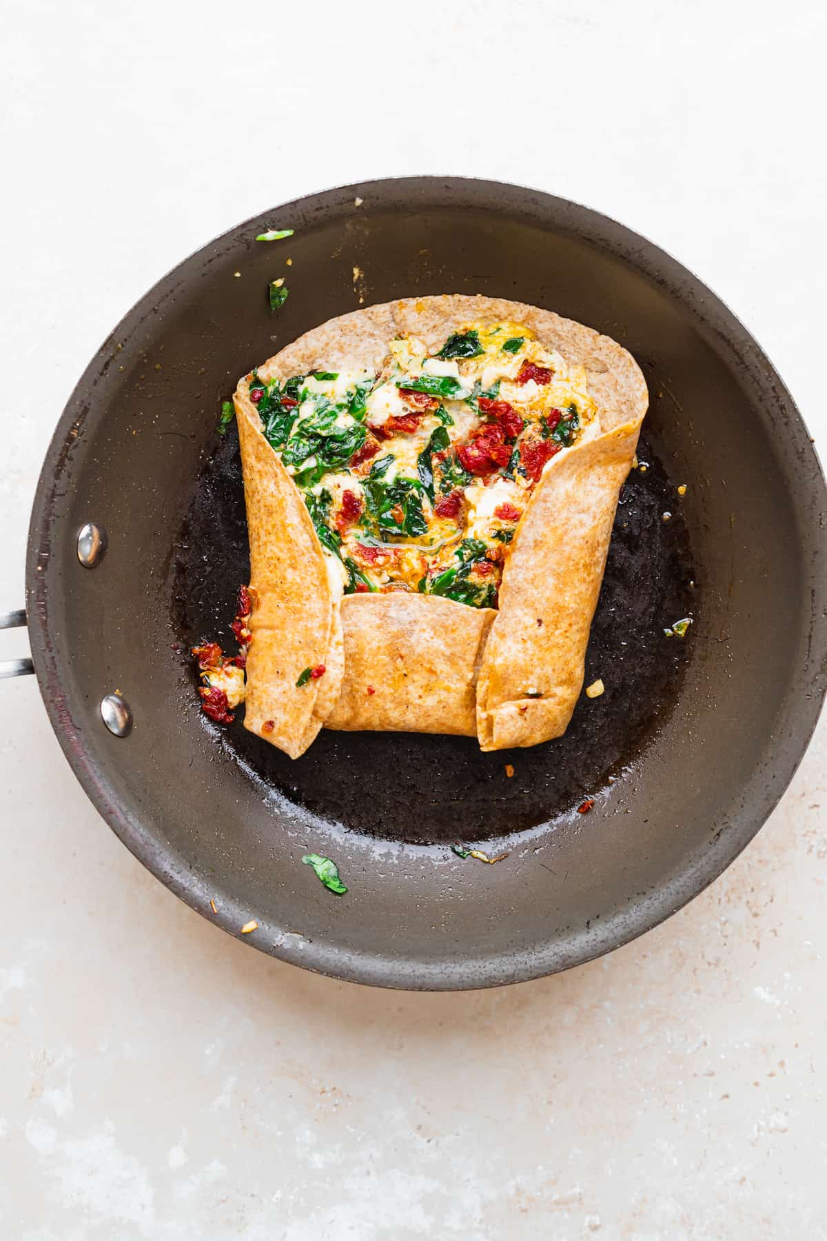 Wrapping the eggs, spinach, and sun dried tomatoes into a hot tortilla. 