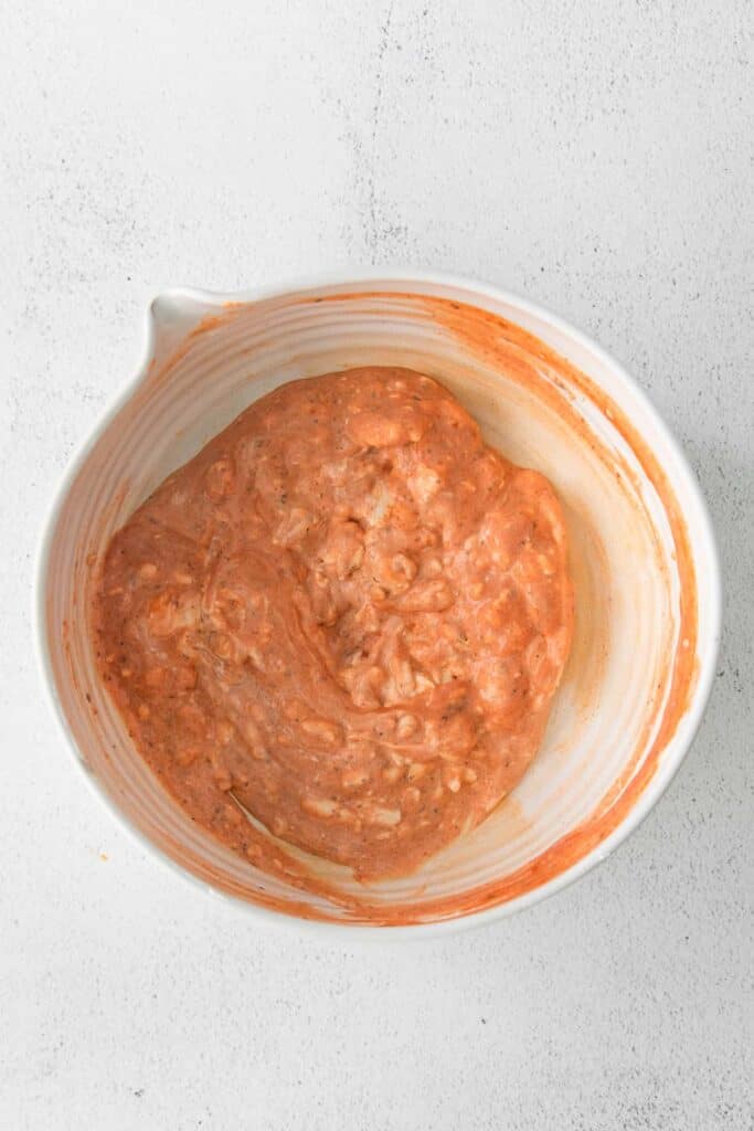 Mixing buffalo chicken dip in a bowl. 