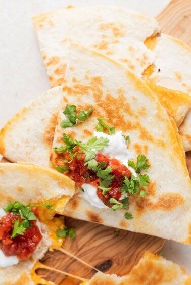 quesadillas on a wooden cutting board.