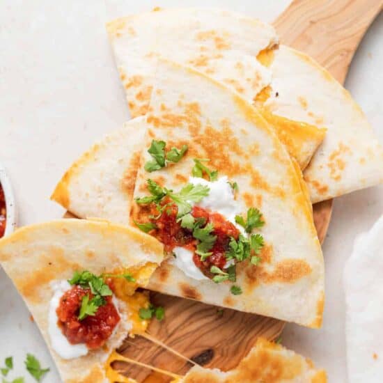 quesadillas on a wooden cutting board.