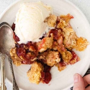 A scoop of ice cream on a white plate.