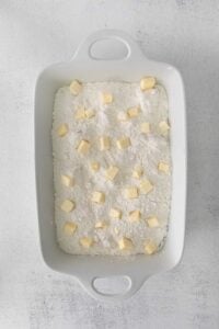 a cream cheese cherry dump cake served in a white baking dish.