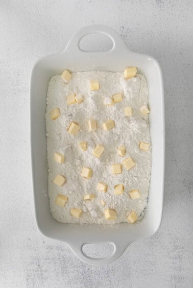 a cream cheese cherry dump cake served in a white baking dish.