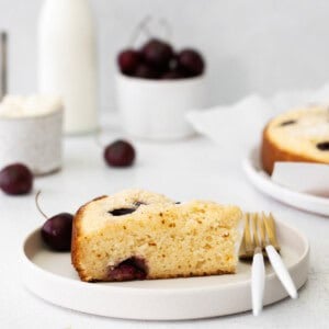 A cherry ricotta cake slice on a plate.