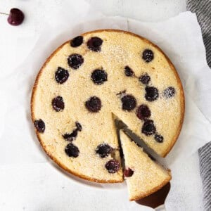 a slice of cherry ricotta cake on a white plate.