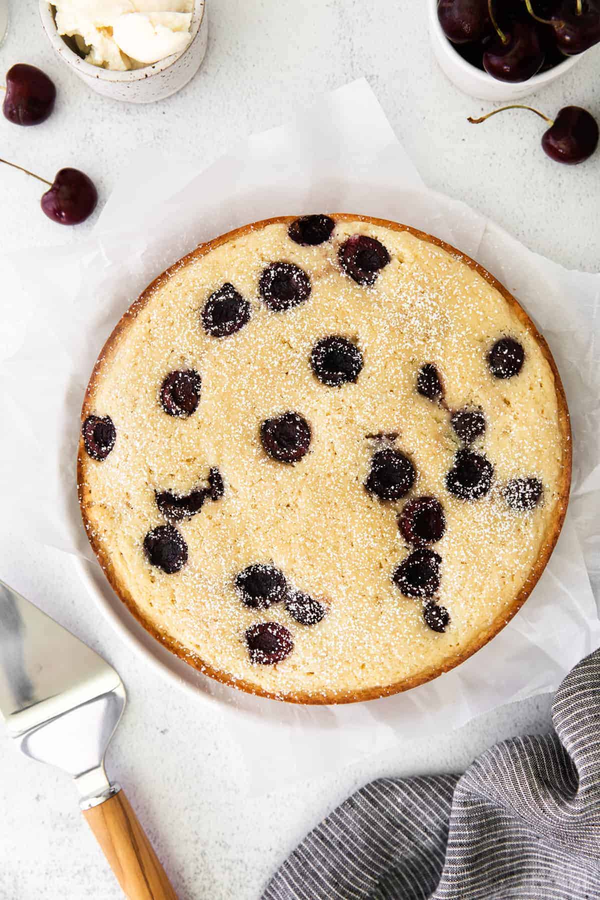 Whole cherry ricotta cake on counter.